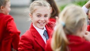 a smiling girl with a red blazer