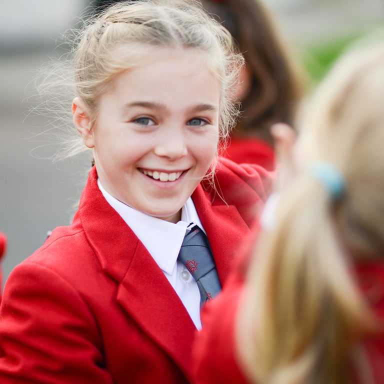 a smiling girl with a red blazer