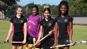 4 girls with hockey sticks