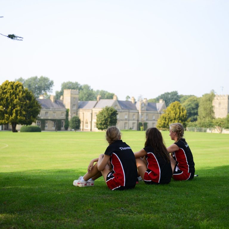 3 college girls sat on the grass