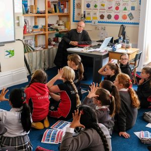 children sitting infront of a smart board