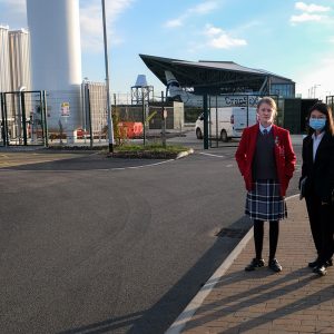 children standing outside of a factory