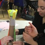 children attaching a ball to tissue rolls