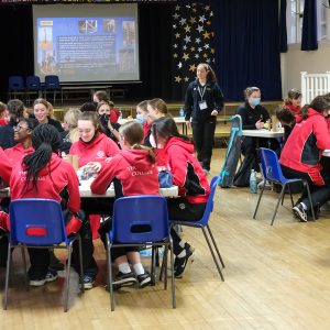 children sitting at tables in a hall