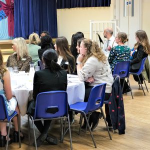 children and teachers sitting at tables