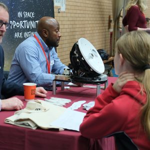 student talking to a man at a table