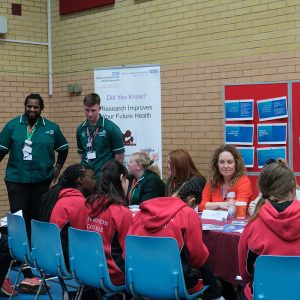 students in a group talking to staff