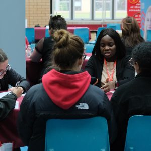 students in a group talking to a member of staff
