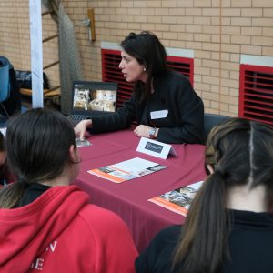 Students listening to a member of staff from a company