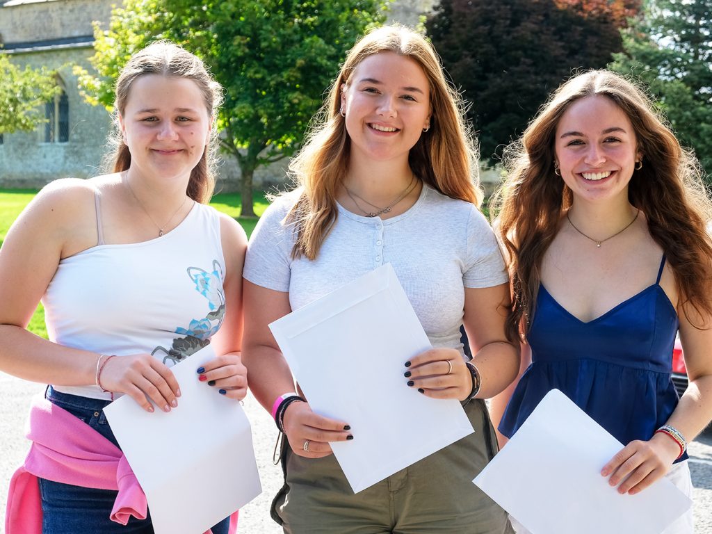 students holding their results envelopes