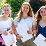 students holding their results envelopes