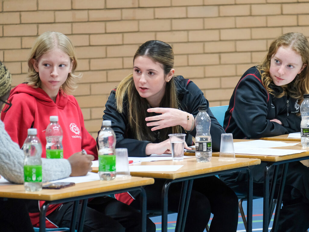 students debating at a desk